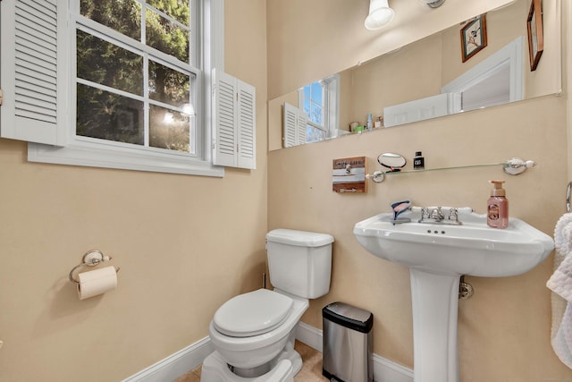 bathroom featuring baseboards and toilet