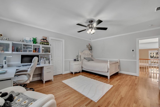 bedroom with ornamental molding, visible vents, ceiling fan, and light wood-style flooring