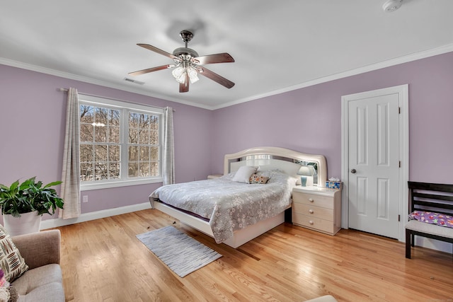 bedroom featuring ornamental molding, visible vents, light wood-style flooring, and baseboards