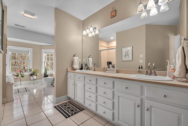 full bathroom featuring double vanity, tile patterned flooring, a shower stall, and a sink