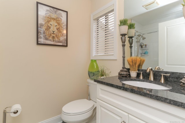 bathroom featuring baseboards, visible vents, toilet, walk in shower, and vanity