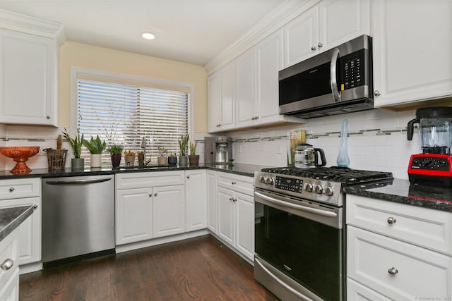 kitchen featuring appliances with stainless steel finishes, dark wood finished floors, white cabinets, and a sink