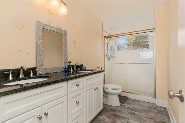 full bathroom featuring a stall shower, a sink, and toilet