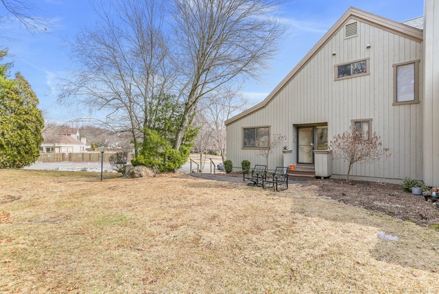 rear view of house with entry steps and fence