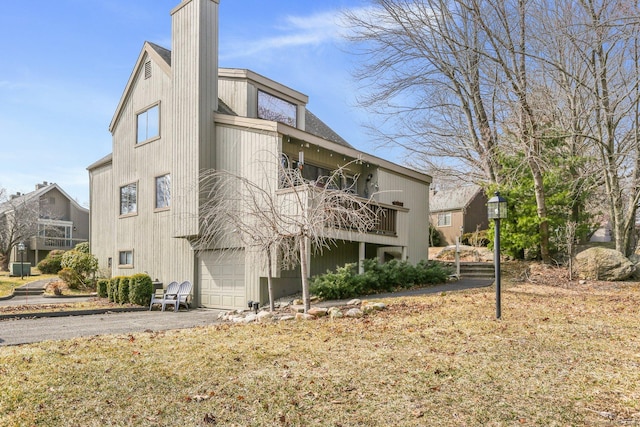 exterior space featuring a garage, driveway, and a balcony