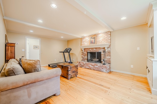 living room with a fireplace, baseboards, light wood-style floors, beamed ceiling, and crown molding