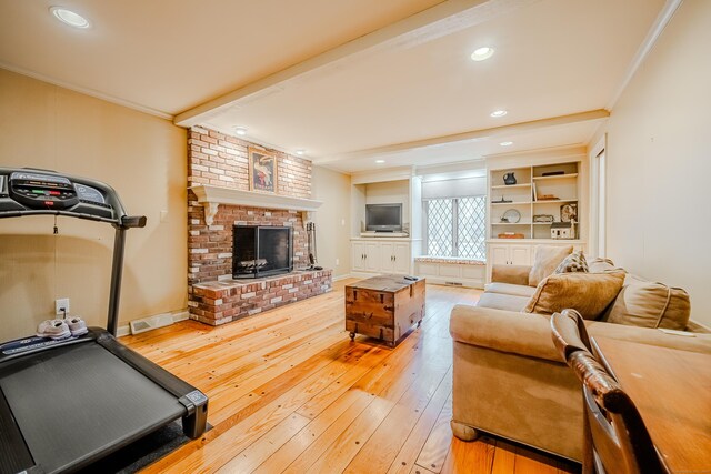 living room with visible vents, a brick fireplace, beamed ceiling, wood-type flooring, and crown molding