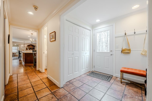 entrance foyer with baseboards, ornamental molding, and recessed lighting