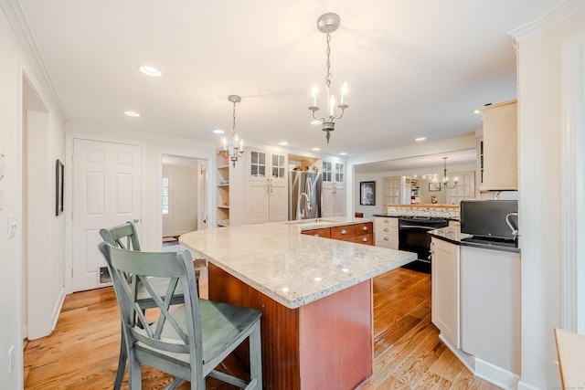 kitchen featuring black electric range, crown molding, a large island, light wood finished floors, and freestanding refrigerator