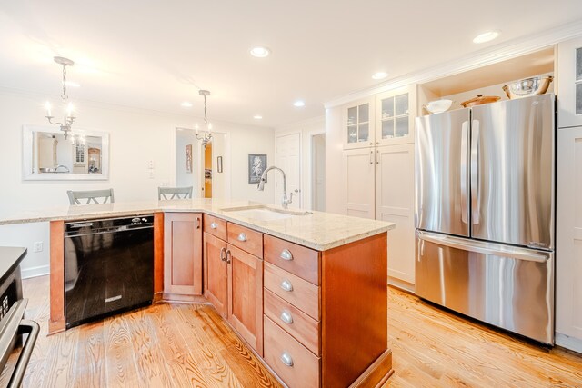 kitchen with black dishwasher, a notable chandelier, light wood-style flooring, freestanding refrigerator, and a sink