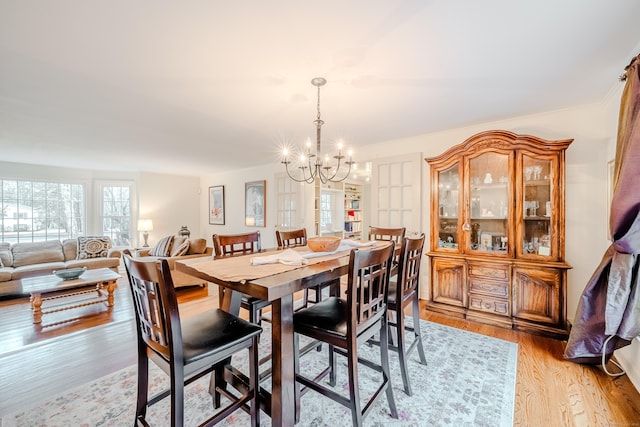 dining space featuring an inviting chandelier and light wood-style floors