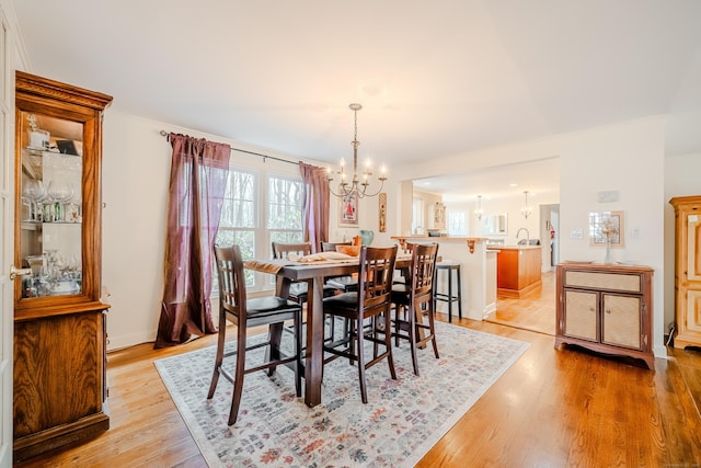 dining room featuring light wood-style floors and a notable chandelier