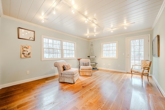 sitting room with light wood-style flooring, ornamental molding, and baseboards