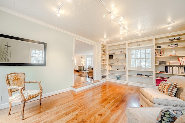 living area with plenty of natural light, crown molding, and wood finished floors