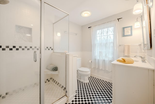 full bathroom featuring a shower stall, toilet, and vanity