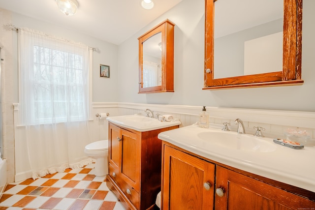 full bath featuring a wainscoted wall, toilet, vanity, and tile patterned floors