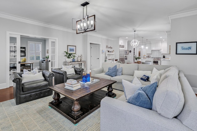 living area with light wood-type flooring, an inviting chandelier, baseboards, and crown molding