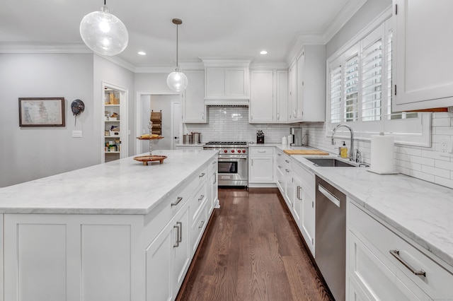 kitchen with dark wood finished floors, appliances with stainless steel finishes, ornamental molding, white cabinets, and a sink