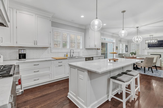 kitchen featuring crown molding, dark wood finished floors, decorative backsplash, white cabinets, and a sink