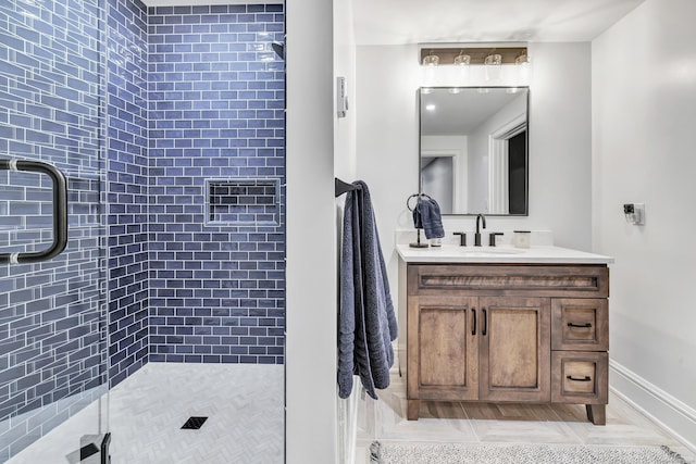 bathroom with a shower stall, baseboards, and vanity