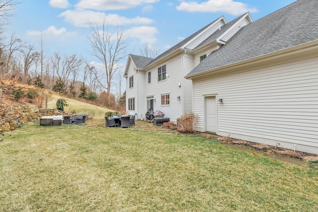 exterior space featuring roof with shingles and a yard