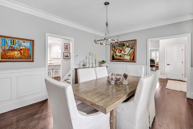 dining room featuring crown molding, wainscoting, and dark wood finished floors