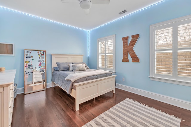 bedroom featuring ceiling fan, dark wood-style flooring, visible vents, and baseboards