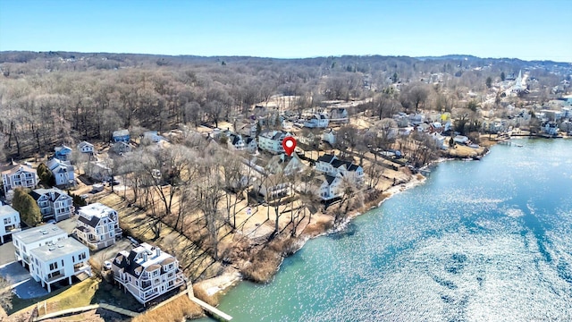 drone / aerial view with a forest view and a water view