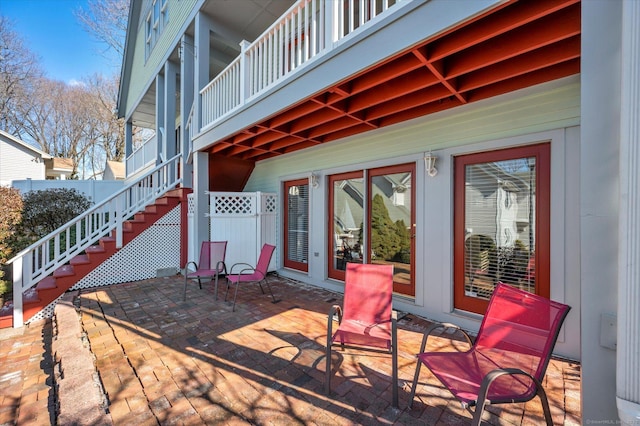 view of patio featuring stairs and fence