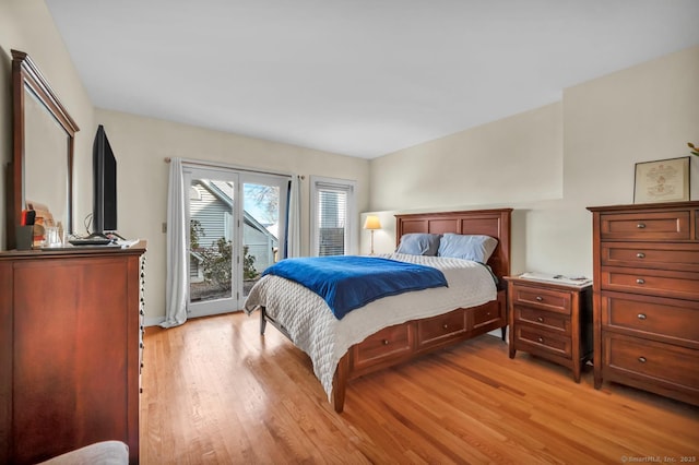 bedroom featuring access to exterior and light wood-style flooring