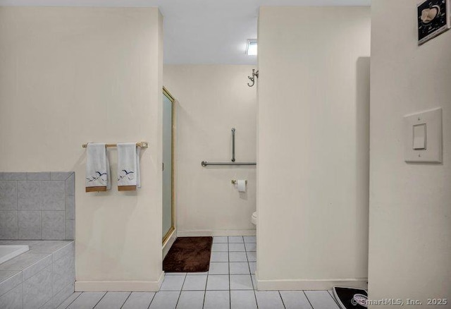 full bathroom with a shower stall, baseboards, toilet, a garden tub, and tile patterned floors