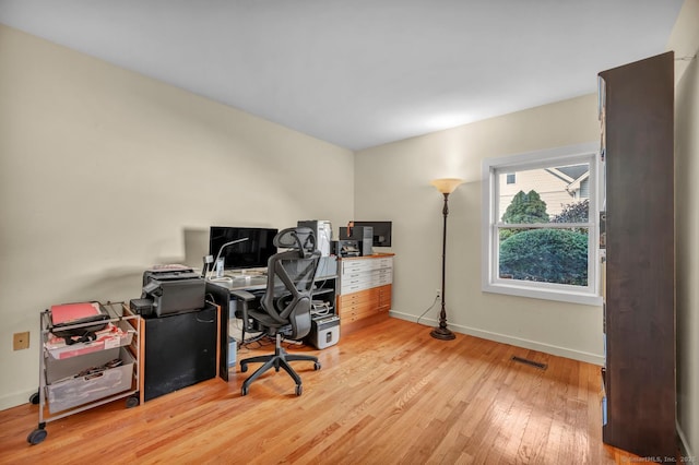 home office featuring visible vents, baseboards, and hardwood / wood-style flooring