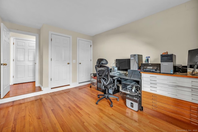 office area with baseboards and wood finished floors