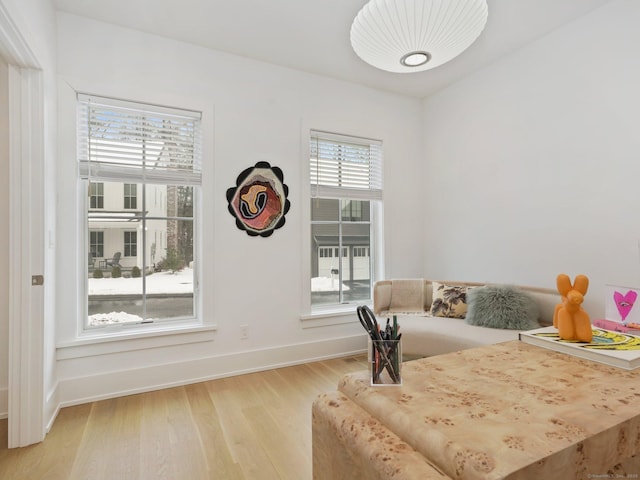 living area featuring light wood-style flooring and baseboards