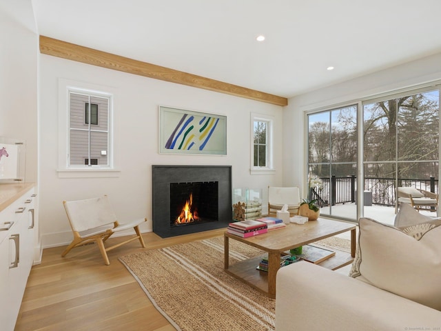 living area with light wood finished floors, a fireplace with flush hearth, baseboards, and recessed lighting