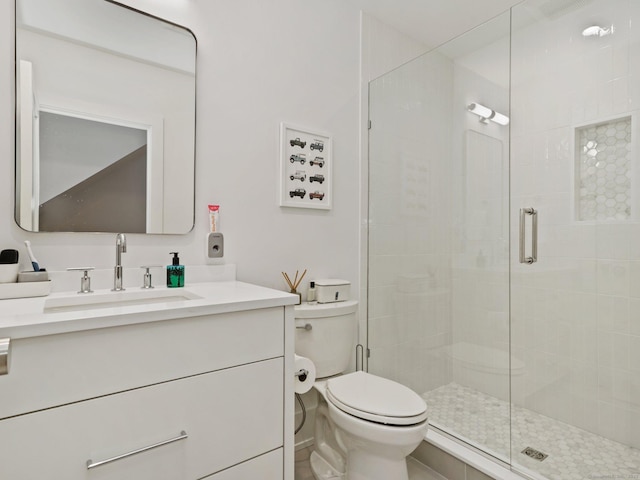 bathroom with a stall shower, vanity, and toilet