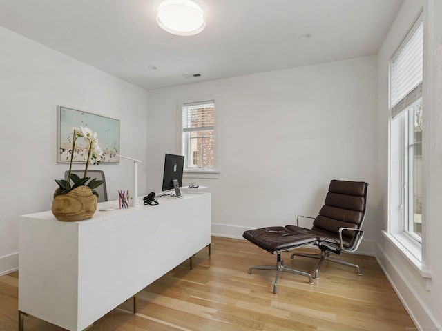 home office featuring light wood finished floors, baseboards, and visible vents