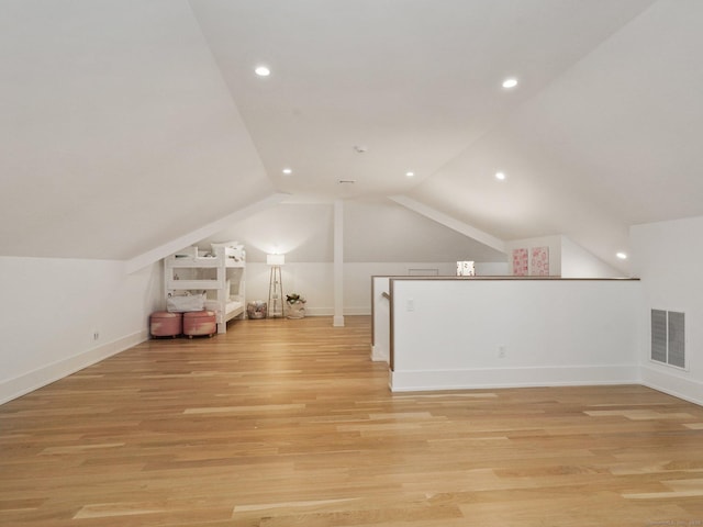 additional living space featuring light wood finished floors, lofted ceiling, recessed lighting, visible vents, and baseboards