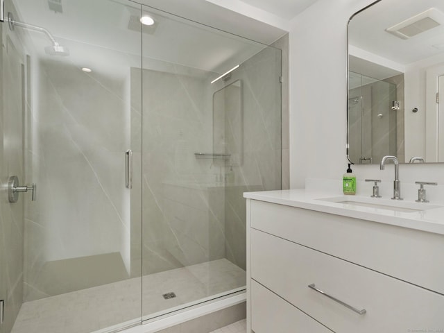 full bath with vanity, a shower stall, and visible vents