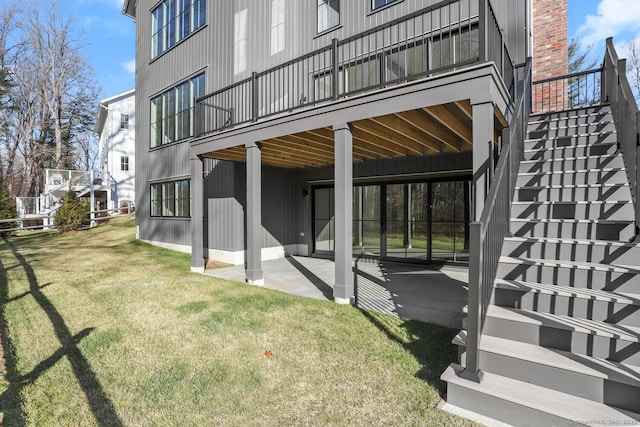 back of house with stairs, a lawn, and a patio