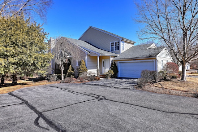 traditional-style home featuring a garage, aphalt driveway, and a chimney