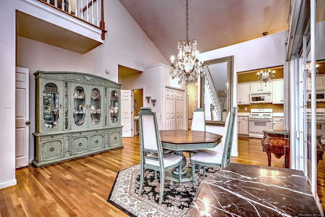 dining space with a chandelier, stairs, and light wood-style flooring