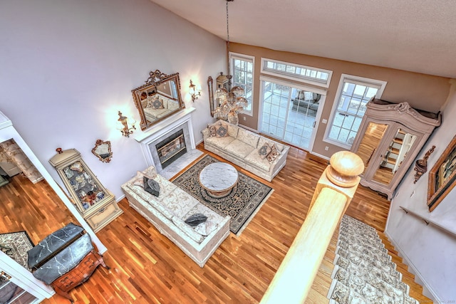 living area with baseboards, a tiled fireplace, and wood finished floors