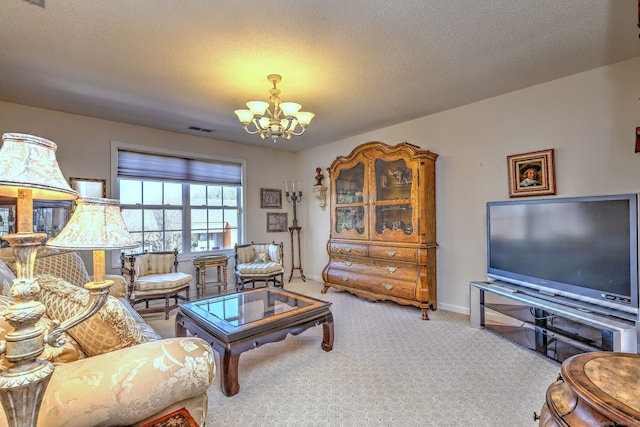 living area with carpet flooring, a notable chandelier, visible vents, and a textured ceiling