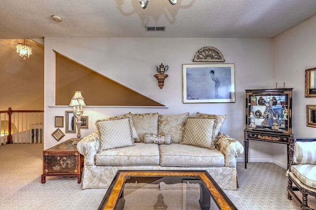 living area featuring carpet floors, visible vents, a textured ceiling, and baseboards