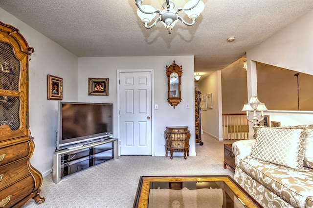 carpeted living area with a textured ceiling, baseboards, and a notable chandelier