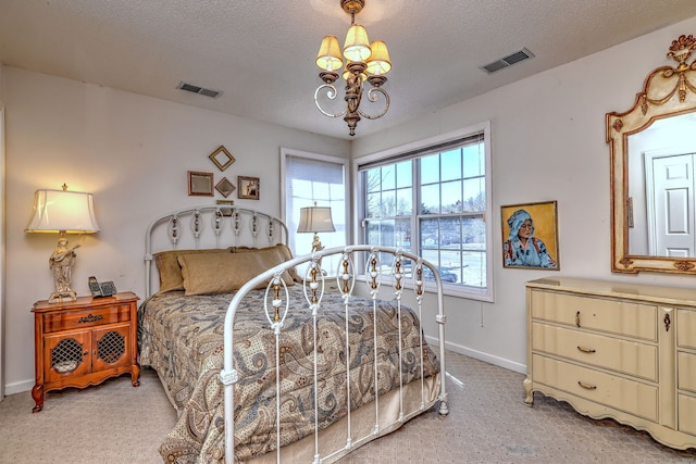 bedroom with a textured ceiling, baseboards, visible vents, and an inviting chandelier