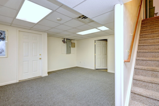 finished below grade area featuring carpet flooring, visible vents, baseboards, stairs, and electric panel