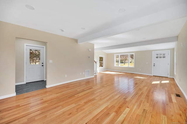 unfurnished living room with light wood finished floors, baseboards, and visible vents