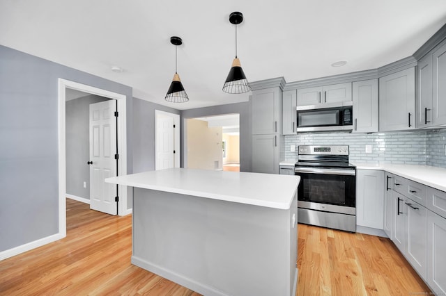 kitchen featuring appliances with stainless steel finishes, light wood-type flooring, gray cabinets, and tasteful backsplash